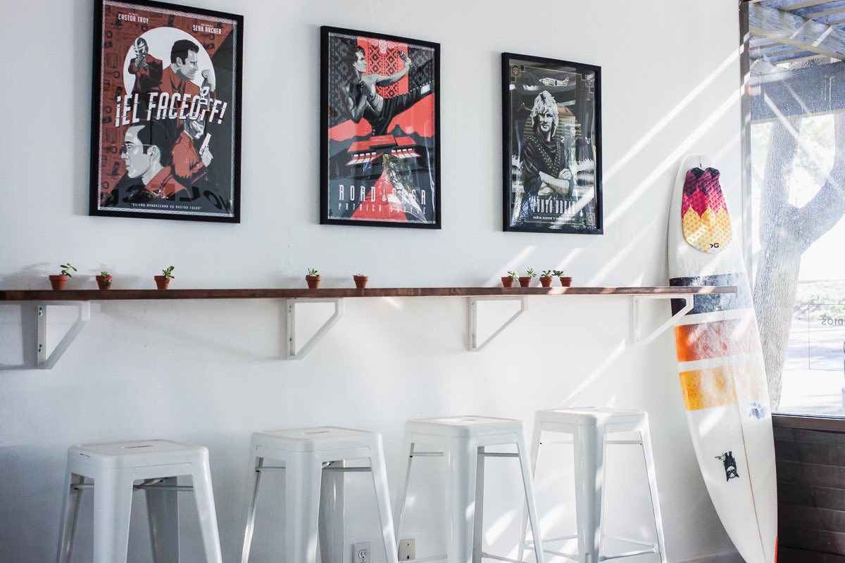 A surfboard leans against the wall near the entrance of Wolf Camp Studios in Costa Mesa, California.