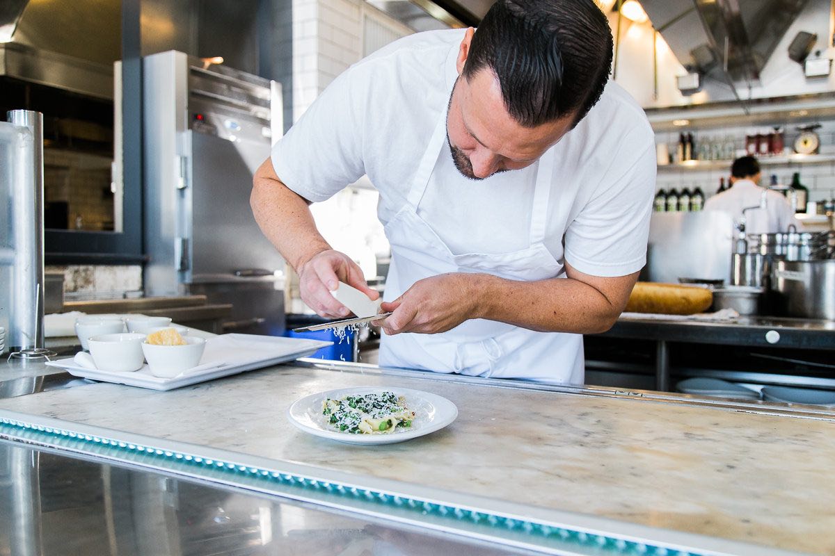 Pizzeria Ortica Executive Chef, Justin Miller, Finishes a Plate with Freshly-Grated Ricotta Salata.