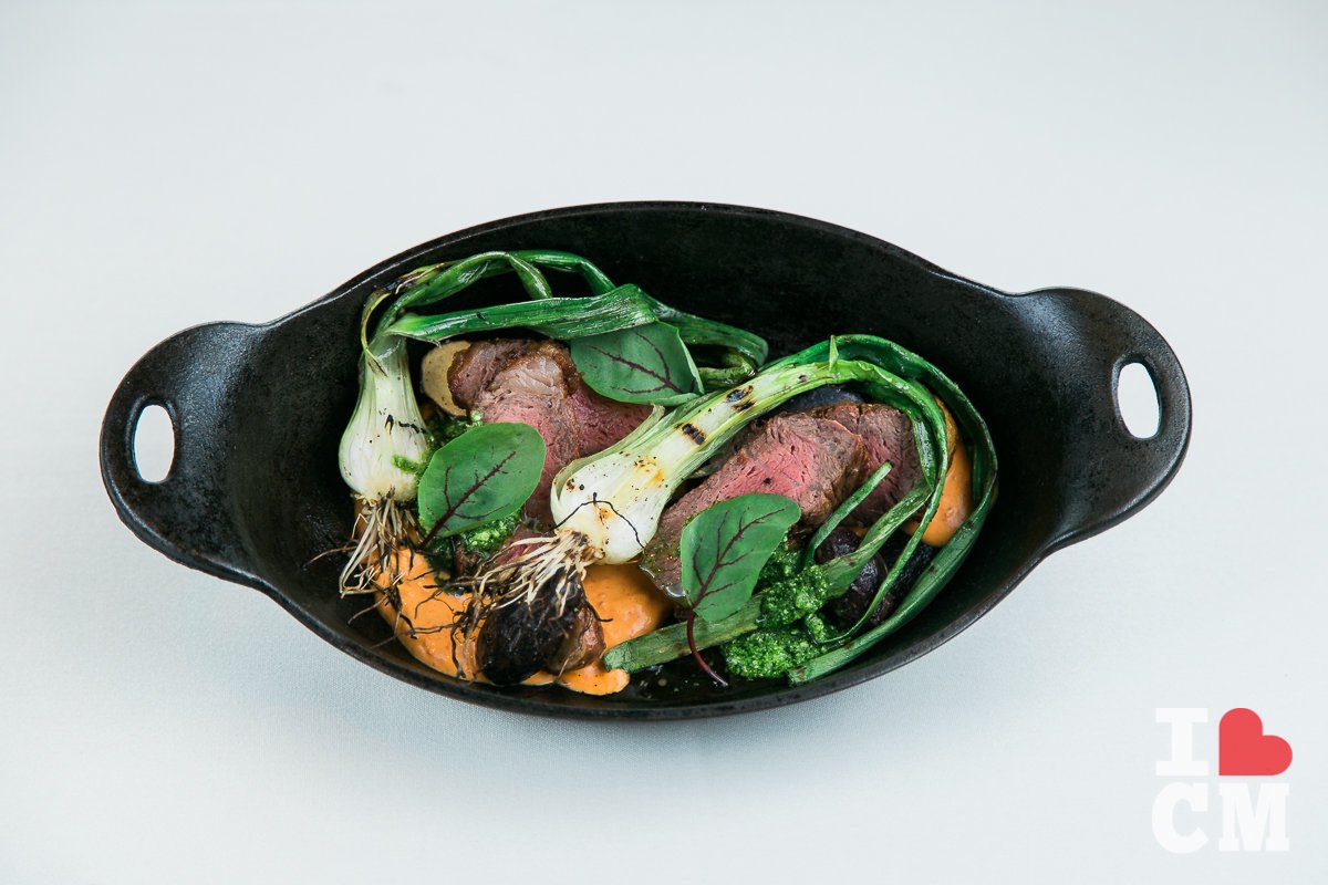 Beautiful Presentation of Prime New York Steak with Roasted Green Garlic Bulbs and Feta Salsa Verde by Mesa Verde Country Club's Executive Chef, Chris Chun