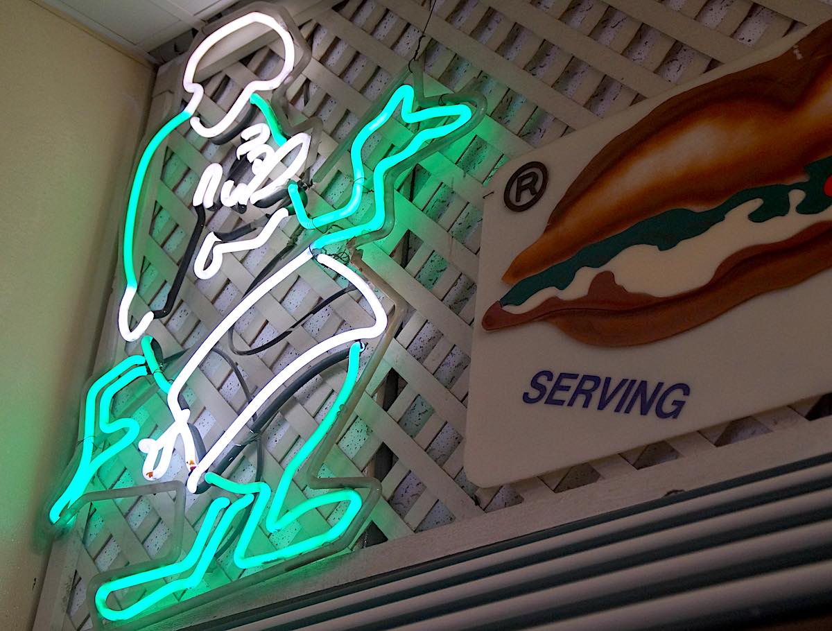 The Lil' Pickle's mascot, an unnamed pickle wearing a chef's hat and apron, has been made into a neon light sign. (Photo: Bradley Zint)