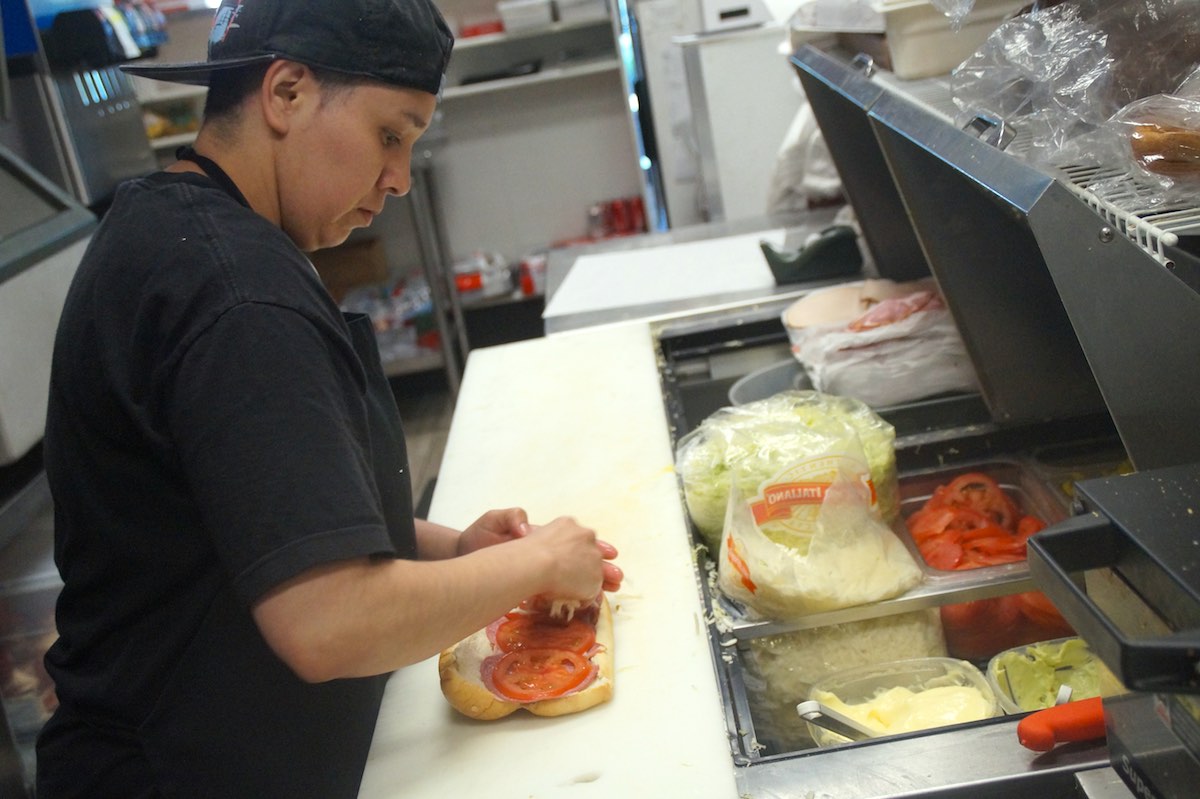 Lil' Pickle employee Zayder Velazquez makes a sub sandwich. She's been at the restaurant for about three years. (Photo: Bradley Zint)