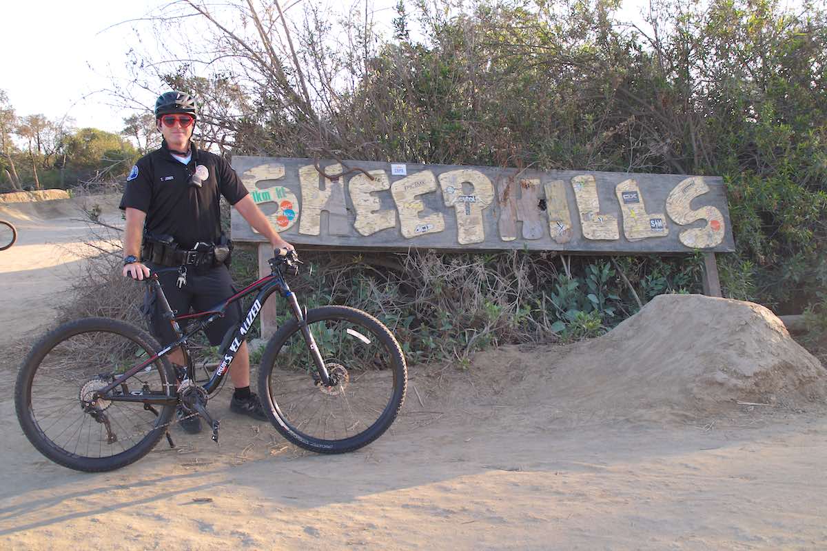 CMPD Officer, Trevor Jones, poses for a photo at Sheep Hills, a legendary BMX bike park in Costa Mesa. Jones got some Internet fame after a video captured him jumping his bike with locals. (photo: Bradley Zint)