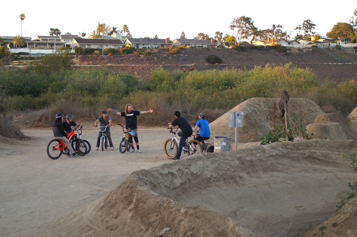 Mike "Hucker" Clark, center, talks to a group of riders at Sheep Hills. Clark is a sponsored professional rider who frequents the park. (photo: Bradley Zint)