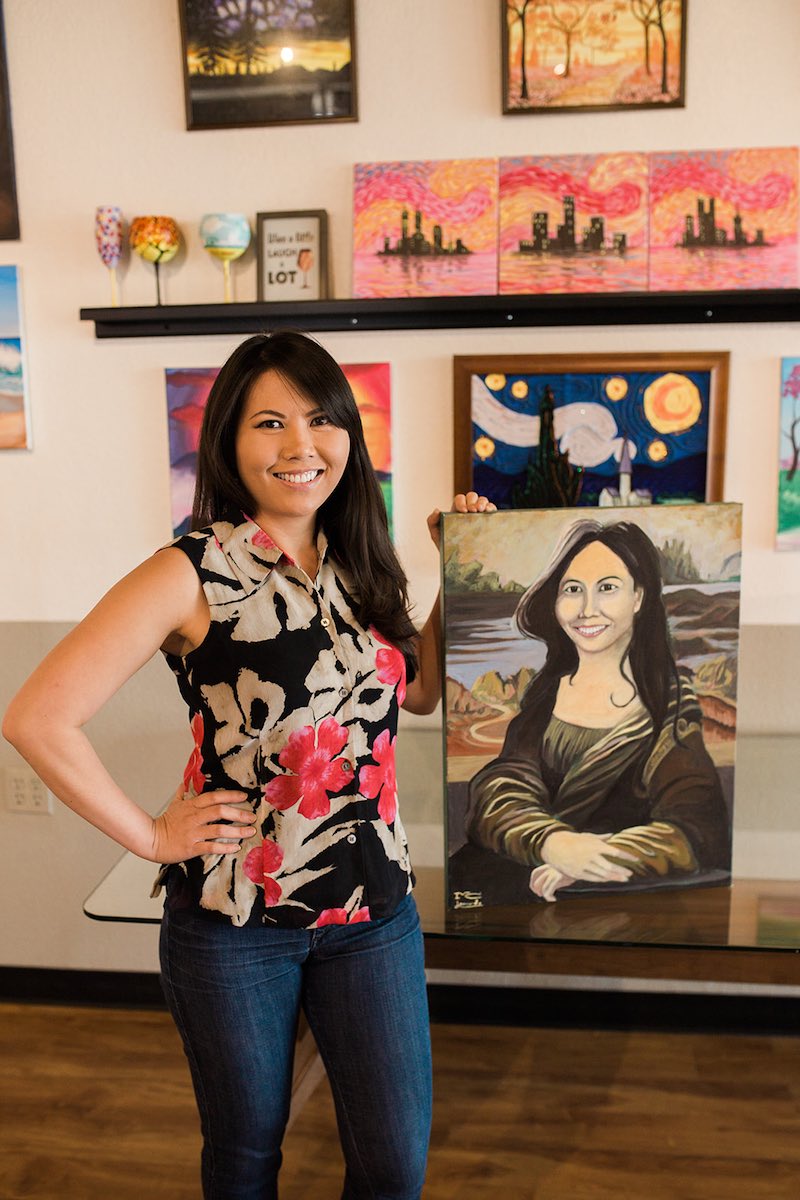 InspiRED Art Wine owner, Karen Nguyen, shows off a "Mona Lisa" inspired painting in her likeness at her studio in Costa Mesa, California. (photo: Brandy Young)