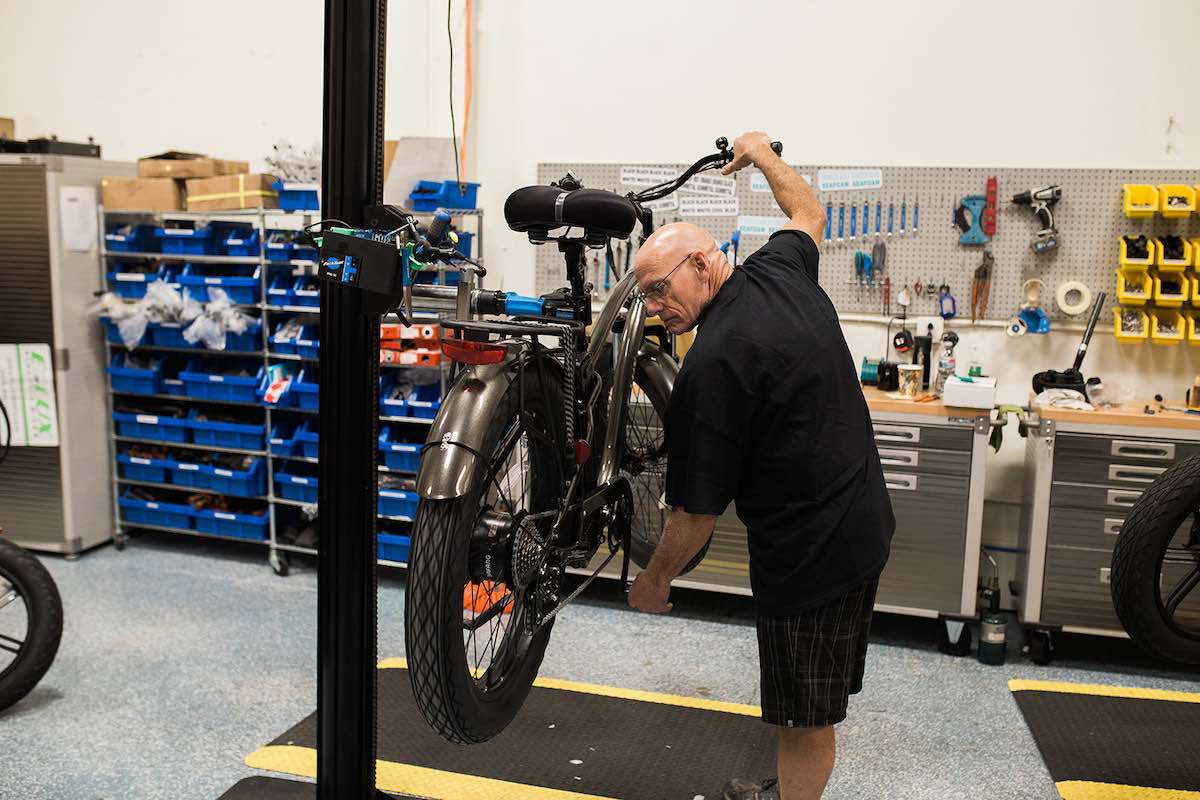 A Bike Mechanic works on an electric bicycle at E-Lux Bikes in Westside Costa Mesa, Orange County, California. (photo: Brandy Young)