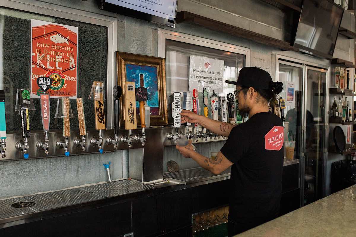 Top Chef, Brina Huskey, pours a beer on tap at his restaurant / pub, Tackle Box, at SOCO and The OC Mix in Costa Mesa, Orange County, California.